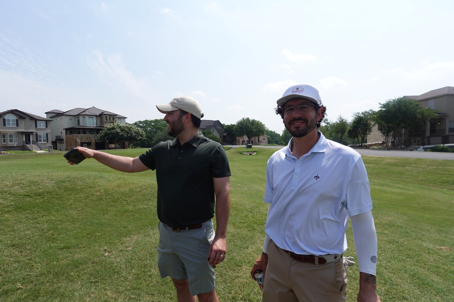 Two men standing on tee box with Breakfast ball golf hat